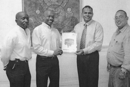Minister of Sport Dr. Frank Anthony receiving a copy of the GAPF’s five-year Strategic Plan from Vice President of the federation, Edwin Spencer. 