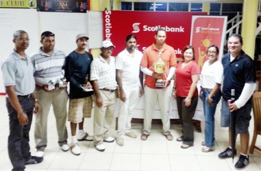 Andre Cummings, fourth from right, displays the winning trophy along with other golfers and representatives of Scitiabank. 