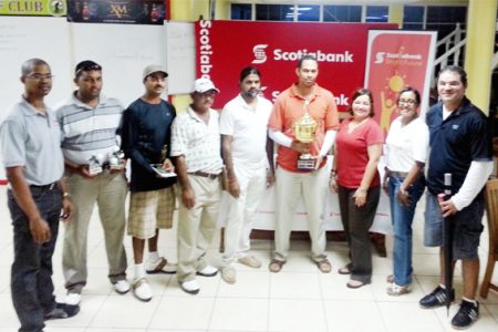 Andre Cummings, fourth from right, displays the winning trophy along with other golfers and representatives of Scitiabank.