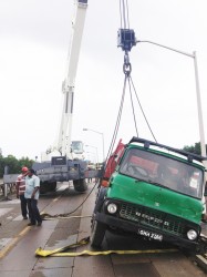 The truck being lifted by a crane from John Fernandes Limited.  
