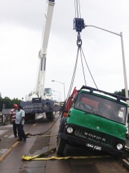 The truck being lifted by a crane from John Fernandes Limited. 