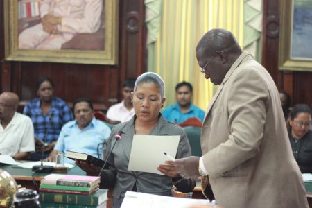 Moruca resident Rennita Williams being sworn in as the APNU’s new Region One Member of Parliament by Clerk of the National Assembly Sherlock Isaacs. (Arian Browne photo)