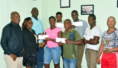 The amateur boxers pose with their cheques as executives of the Guyana Boxing Association and Cuban Coach, Francisco Hernandez Roldan look on. (Orlando Charles photo) 