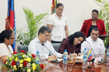 Minister of Foreign Affairs Carolyn Rodrigues- Birkett and her Venezuelan counterpart Elías Jaua Milano sign an agreement to combat narco-trafficking yesterday. (Photo by Arian Browne)