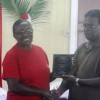 Chief Medex, Ministry of Health, Baldeo James (right) present a long-serving midwife with her award (GINA photo)