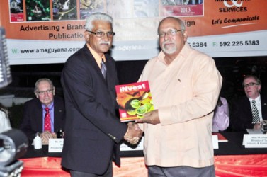 Invest Guyana Publisher Lokesh Singh (left) presents a copy of the Magazine ‘Invest Guyana’ to President Donald Ramotar (GINA photo)