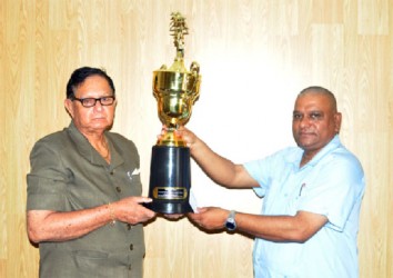 Cecil Kennard receives the cheque and trophy from BCCI CEO Omadat Samaroo yesterday. 
