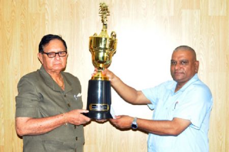 Cecil Kennard receives the cheque and trophy from BCCI CEO Omadat Samaroo yesterday.