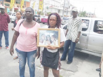 Barbara James (left), mother of the deceased, along with a relative outside the Georgetown Magistrate’s Court yesterday. 