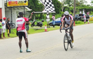 National cyclist, Robin Persaud calmly crosses the finish line in the final stage of the annual Independence three-stage road race yesterday on Homestretch Avenue. (Orlando Charles photo)