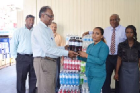 National Sports Commission (NSC) Director. Neil Kumar (left) receives a case of Powerade energy drink from Banks DIH representative Lakerani Sukram yesterday morning.