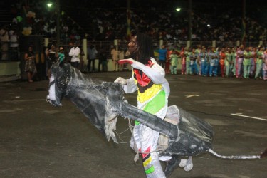 A masquerader performing at the flag-raising