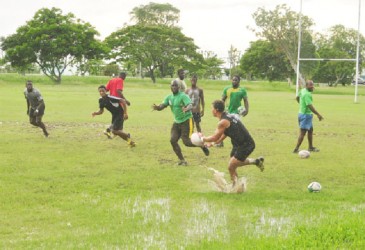 National Rugby captain, Ryan Gonsalves passes the ball to Delroy Gordon during the team’s final practice session yesterday at the National Park before winging out to Trinidad and Tobago this morning. (Orlando Charles photo) 