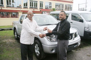 Minister of Home Affairs Clement Rohee (left)  hands over the keys to the vehicles to Head of CANU, James Singh (GINA photo) 