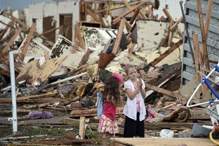 Two girls stand in rubble after a tornado struck Moore, Oklahoma, May 20, 2013.
REUTERS/Gene Blevins