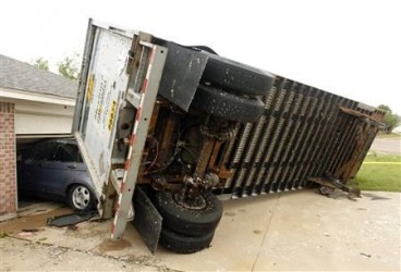 A trailer blown into a home on Lindsay Lane in Cleburne rests on a car after a tornado touch down in Cleburne, Texas May 16, 2013. REUTERS/Richard Rodriguez