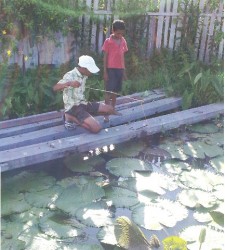 This young man looks on as his friend tries to hook a ‘big’ fish.