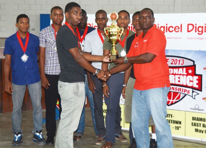 Marian Academy captain Tequain Vieira collects the Georgetown U20 Conference trophy from Digicel’s Event and Sponsorship manager Gavin Hope while the rest of the team looks on.

