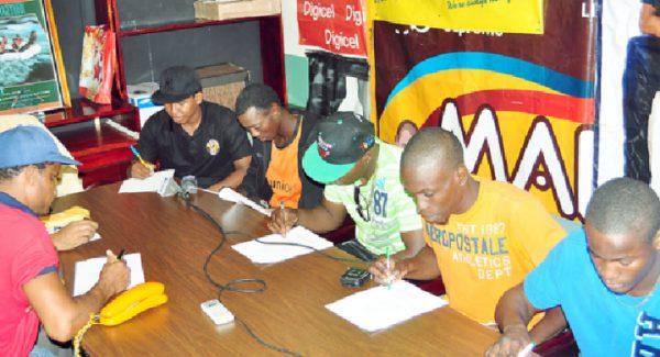 It’s official! Dexter Gonsalves (fourth from right) affixes his signature to his contract to make his ring date with Revlon Lake official. Other boxers signing their contracts yesterday were (from left) Romeo Norville, Kelsey George, Anson Green and Laured Stewart. (Orlando Charles photo)
