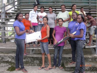 Members of the NYDN handing over cricket gear to Blairmont’s female cricketers 