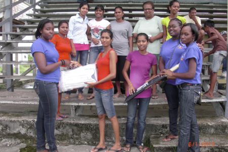 Members of the NYDN handing over cricket gear to Blairmont’s female cricketers

