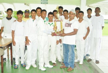 West Demerara Captain, Travis Persaud, receives the winning trophy from DCB Junior Selection Committee Chairman, Nazim Drepaul. 