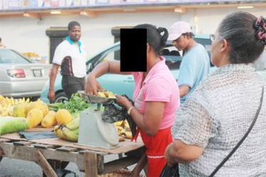 A vendor at Bourda Market using a dial scale yesterday.  