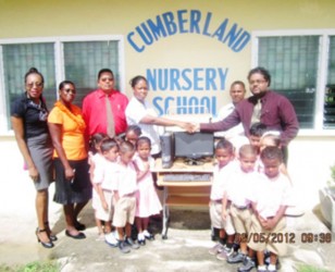 Berbice Chamber of Commerce past president Imran Sacoor (right) presents a computer system to the Cumberland Nursery School at a ceremony attended by pupils of the school and Chamber representatives. 