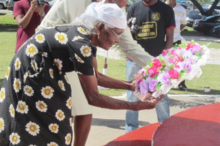 Pooran’s widow, the closest surviving relative of the Enmore Martyrs, is given support as she lays a wreath under her husband’s name. 