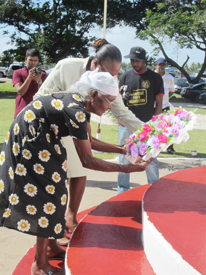 Pooran’s widow, the closest surviving relative of the Enmore Martyrs, is given support as she lays a wreath under her husband’s name. 