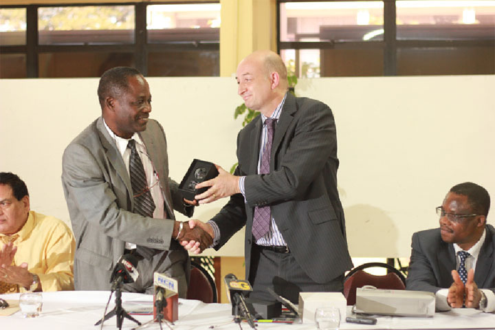 UClan’s Deputy Vice Chancellor Professor Dave Phoenix (right) presents UG’s Vice Chancellor Jacob Opadeyi with a symbol of the partnership their institutions share after the signing of the MOU between the two universities yesterday.  