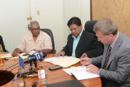Finance Minister Dr Ashni Singh (centre) looks on as European Union Ambassador Robert Kopecky signs the Financing Agreement. Also in photo is senior Finance Ministry official Tarachand Balgobin. (GINA photo)
