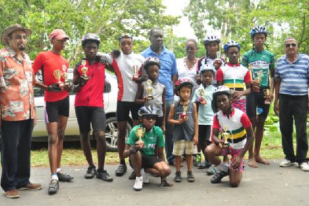 Winners and runners up pose with their trophies upon completion of yesterday’s fourth annual World Olympic Day five-race BMX cycle programme. They are flanked by president of the GOA, K Juman-Yassin (extreme left), Joseph Britton, president of the GCF, Cheryl Thompson and National Cycling Coach, Hassan Mohamed. (Orlando Charles photo)