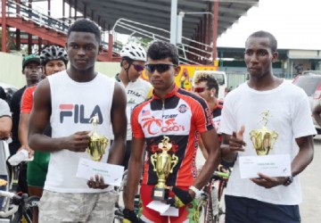 Olympic Day Triathlon winners, Daniel Scott, Raynauth Jeffery and Cavin McDonald with their trophies and prize money after the activity in the National Park.