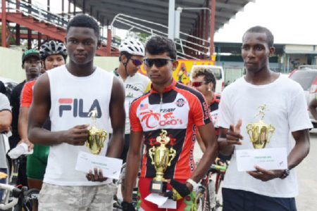Olympic Day Triathlon winners, Daniel Scott, Raynauth Jeffery and Cavin McDonald with their trophies and prize money after the activity in the National Park.