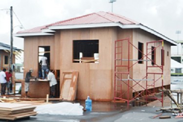 Persons working on a model of one of the houses that would be on display at Building Expo 2013 (Government Information Agency photo) 