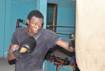 Dexter Gonsalves hitting the punching bag during one of his recent training sessions at the Forgotten Youth Foundation (FYF) Gym. (Orlando Charles photo) 