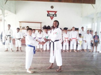 Ethan Puri on behalf of his parents presents Nathalie Gibson (right) with the cheque at the Young Men Christian Association (MYCA) after training.