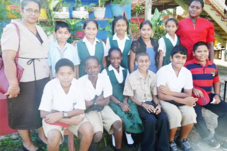 Teachers, Shamena Charran (left) and Magdalene Sobers-Williams posing with the top students of Novar Primary