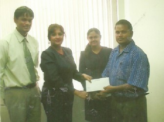 Senior Supervisor of Republic Bank Rose Hall Branch, Seema Bridemal, hands over sponsorship cheque to RHTYSC’s Rohan Etwaru.