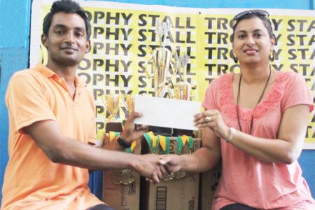 Treasurer of the GCF Ryan Singh collects the sponsorship cheque and trophies for the tournament from Devi Sunich of the Trophy Stall.