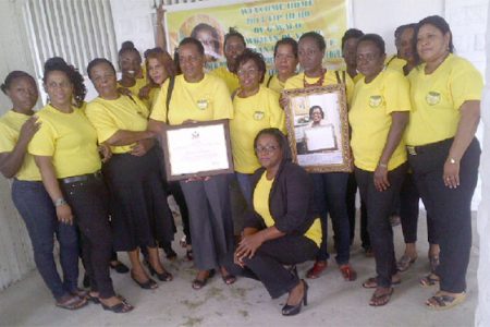 Simona Broomes (stooping) and other members of the GWMO executive with her award.