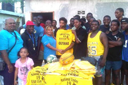 Shenny Lall, manager of the Long Hi Industries presenting a quantity of jerseys to captain of the national under-19 rugby team, Godfrey Broomes in the presence of the coaches, Laurie Adonis and Troy Yhip and other ruggers.