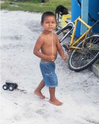 This boy did not mind having his picture  taken with the string in his mouth.