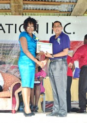 Blairmont Champion worker, Avril Patricia Spencer receives her certificate from Jairam Petam (GINA photo) 