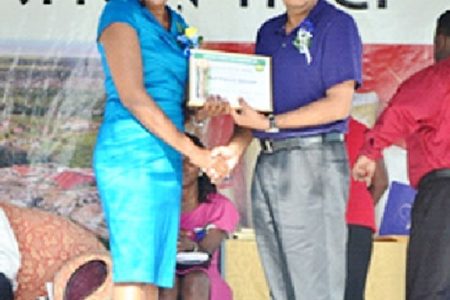 Blairmont Champion worker, Avril Patricia Spencer receives her certificate from Jairam Petam (GINA photo)
