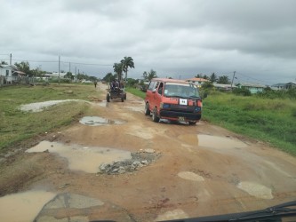 A bus manoeuvring through the many potholes in the main road leading into 'C' Field Sophia