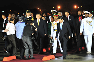 Chinese President Xi Jinping, left, and Prime Minister Kamla Persad-Bissessar are followed by Foreign Affairs Minister WInston Dookeran and President Anthony Carmona, circled, at South Terminal, Piarco International Airport, on Friday night after the arrival of the Chinese leader on a State visit.