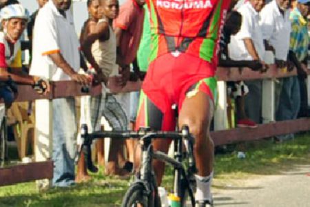 National cyclist, Alonzo Greaves, raises his hand in victory after powering to his ninth signature win of the season yesterday at the Seawall Bandstand. (Orlando Charles photo)
