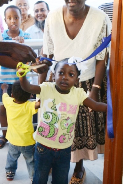 A resident of Sophia assisting in cutting the ribbon. (GINA photo)